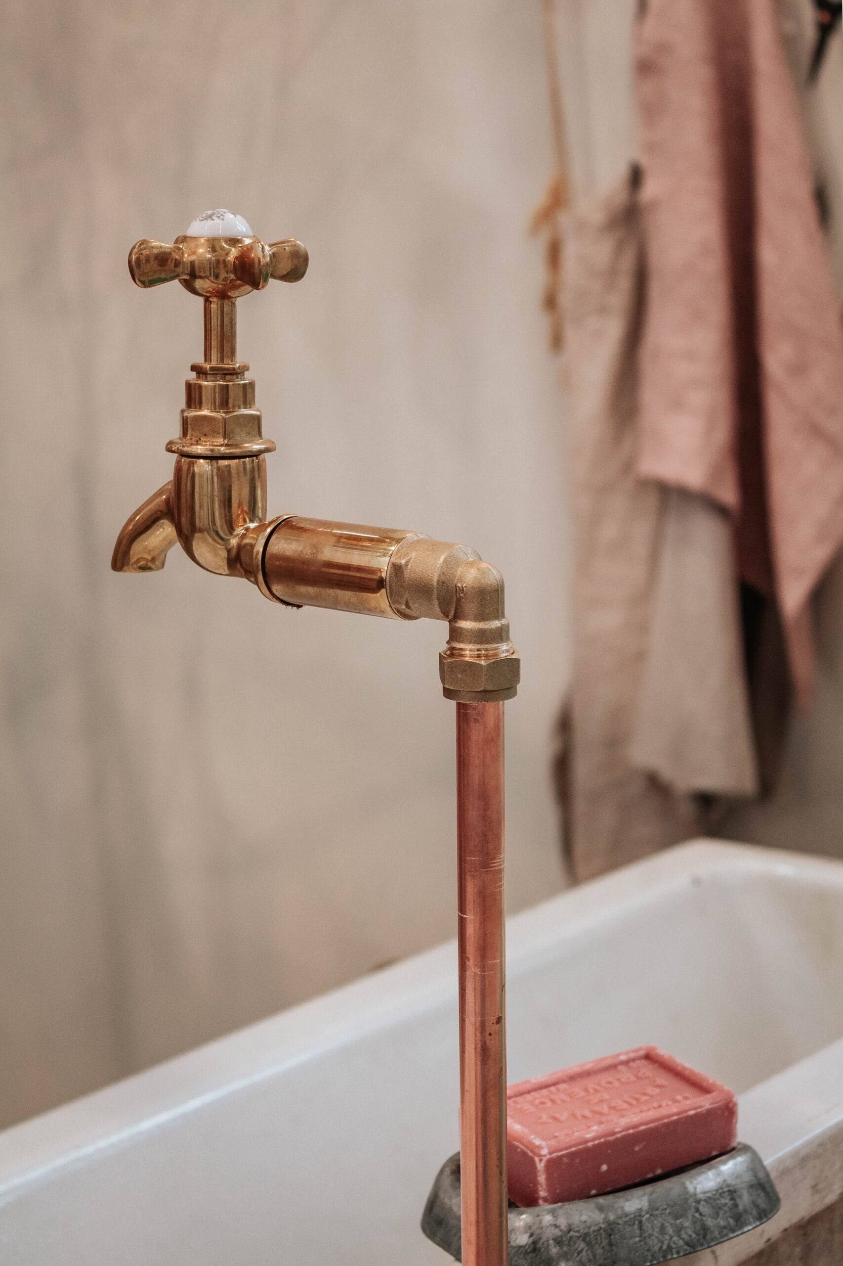 brass faucet near bathtub